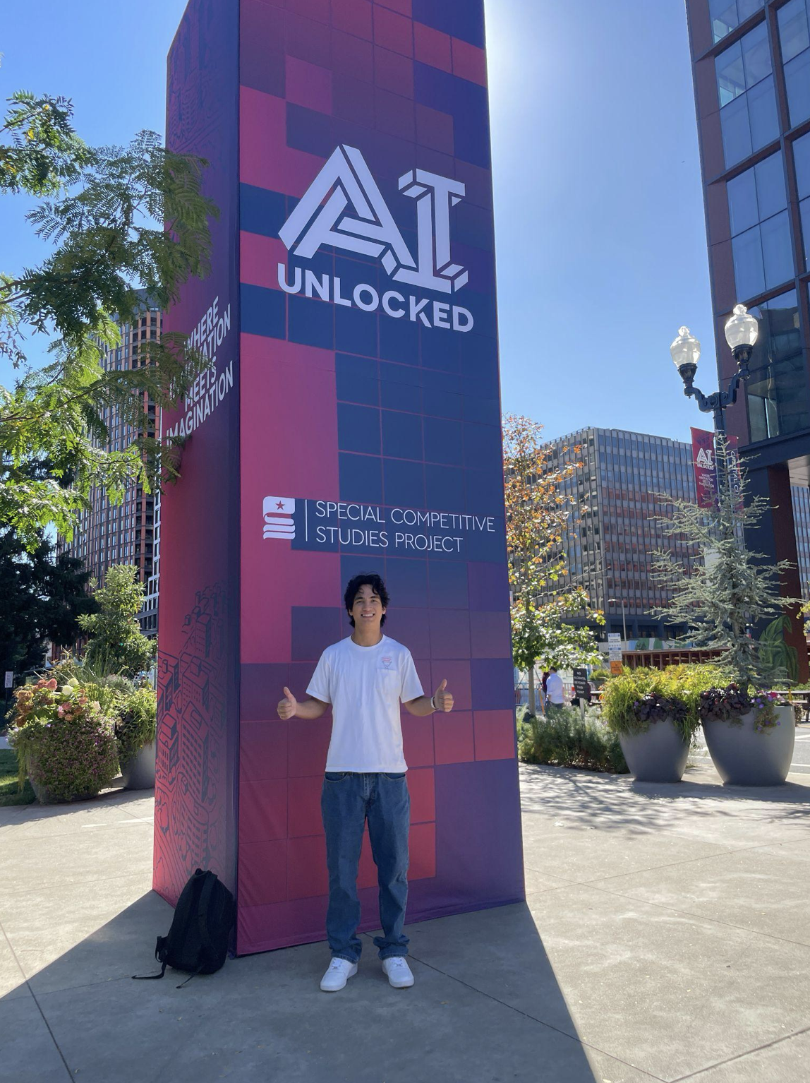 A man stands in front of a banner that reads "AI Unlocked"